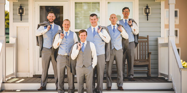 Groomsmen standing in front of a cottage at The Lodge at Geneva-on-the-lake